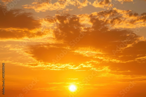 A vibrant golden sunset with soft, wispy clouds creating serene and warm natural outdoor backdrop