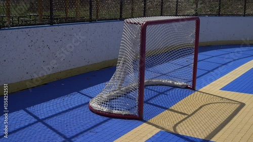 Slow panning shot of dek hockey rink net during the spring summer time