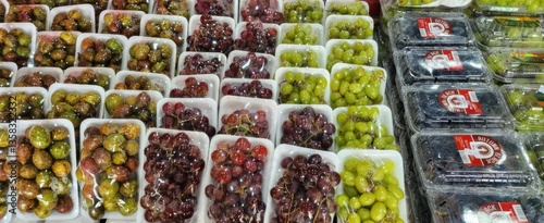 Various bunches of grapes neatly arranged and ready for purchase