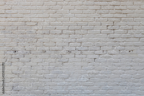 Full frame abstract texture background of a grungy white painted antique brick wall that shows some weathering and peeling paint