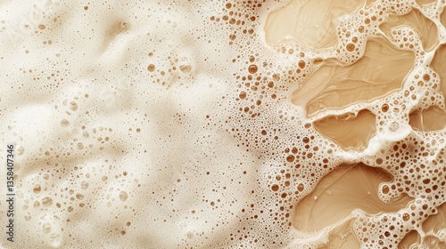 Translucent droplets of hydraulic fluid swirl creating creamy beige foam texture against a backdrop of darker liquid swirls