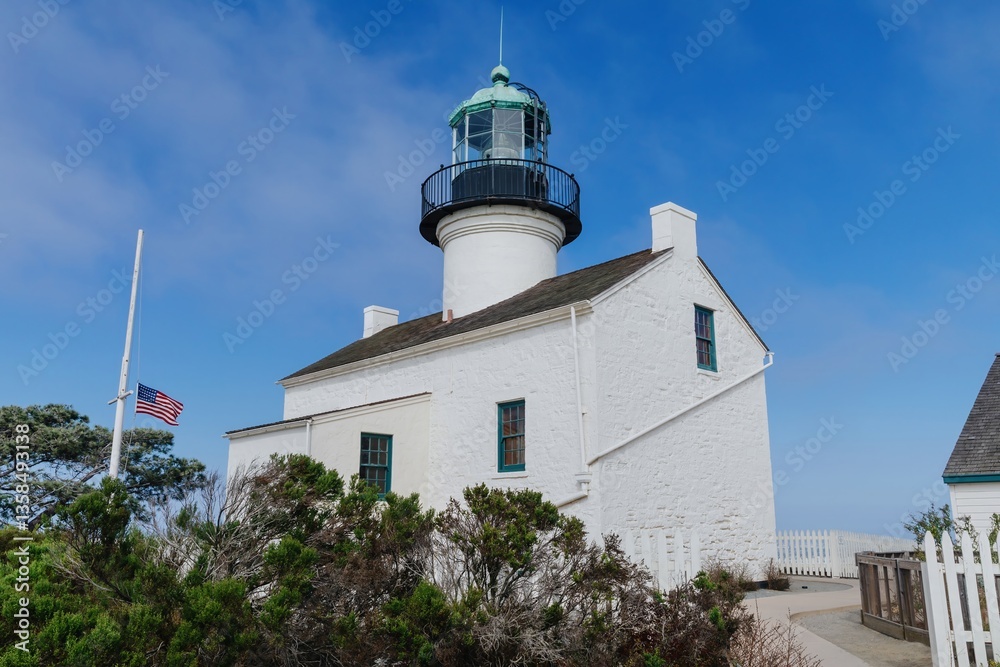 The Old Point Loma Lighthouse stands tall against a clear blue sky in San Diego, California, USA. The historic landmark served to guide ships safely into the harbor. The Old Point Loma Lighthouse stands tall against a clear blue sky in San Diego, California, USA. The historic landmark served to guide ships safely into the harbor.