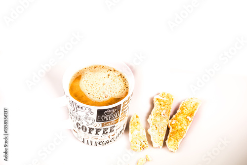 A mug of foamy freshly brewed organic coffee and Italian Biscotti pastries isolated against a white background 