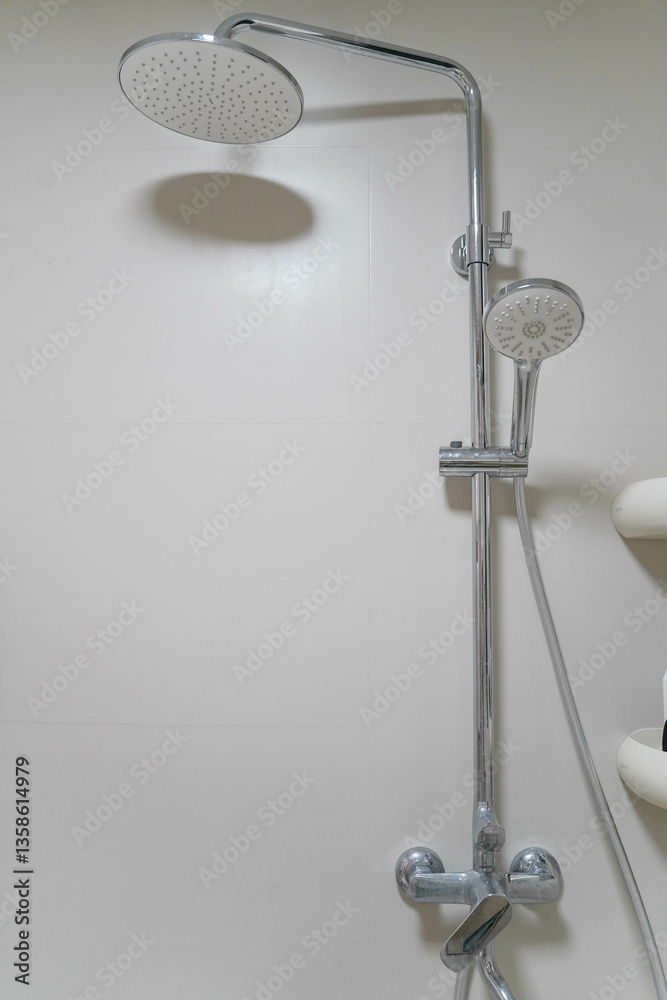 Modern shower zone with rain head, hand held shower. Beige tiles in the bathroom
