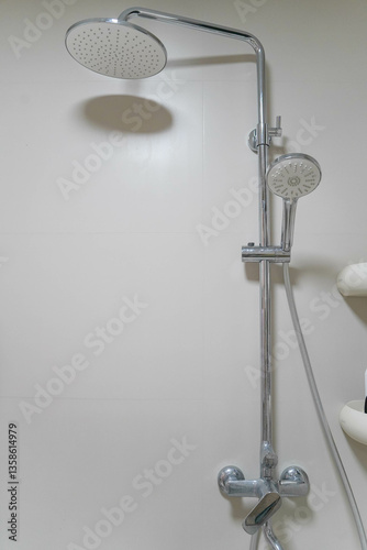 Modern shower zone with rain head, hand held shower. Beige tiles in the bathroom
