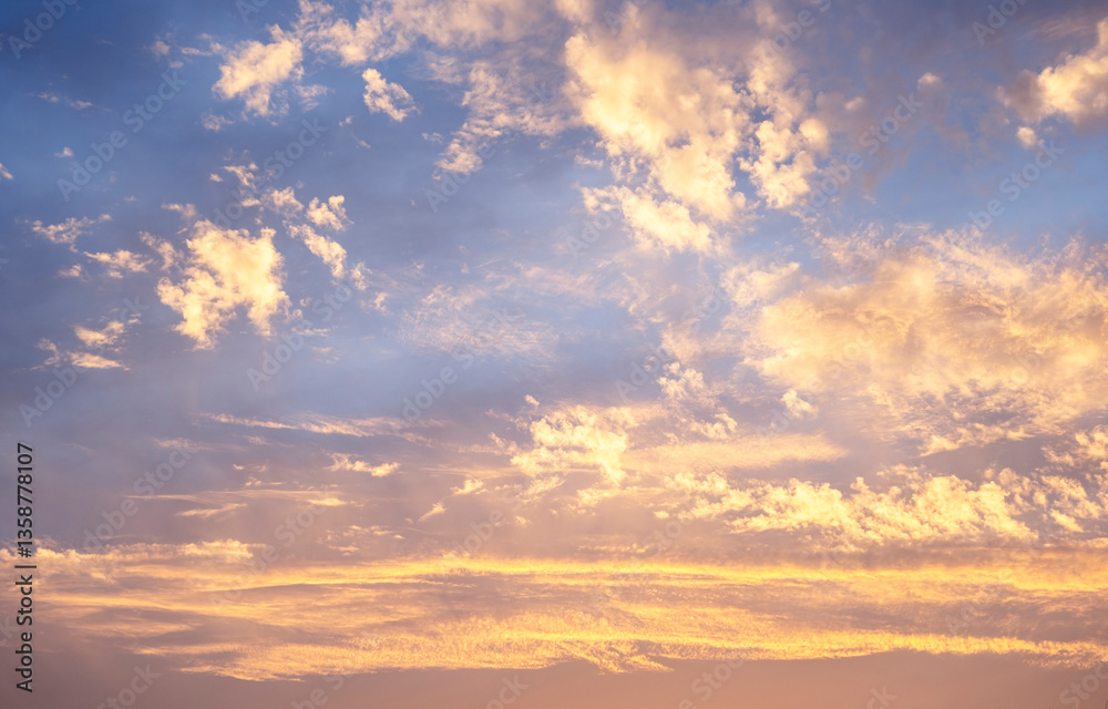 Obraz premium Sky clouds sunset background. Stunning view of golden, lilac and pink clouds and blue sky