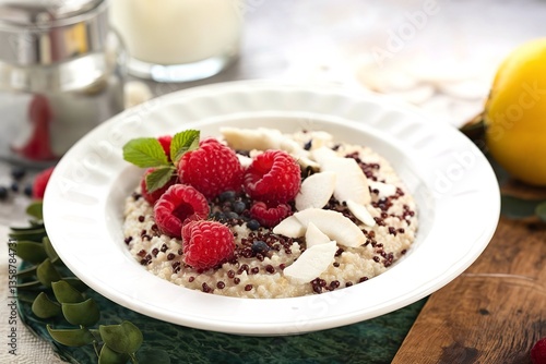 Quinoa porridge with raspberry and coconut flakes for breakfast