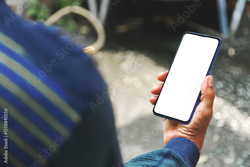 Image of man's hand holding a smartphone with white space on the mobile screen for inserting text or advertising banner.