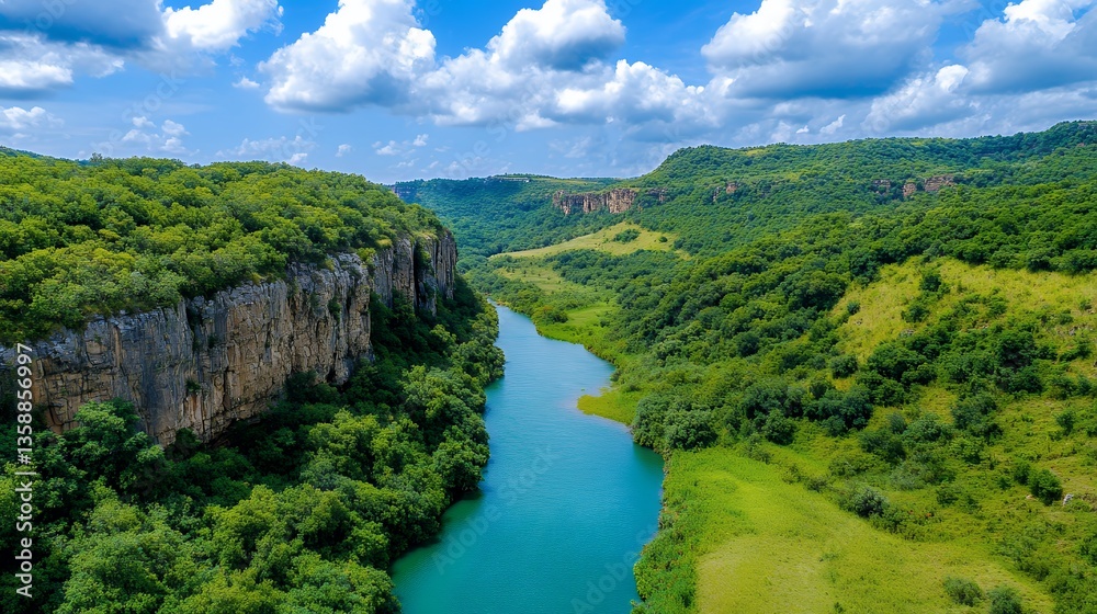 Obraz premium Serene Aerial View of Turquoise River Flowing Through Lush Green Canyon Under a Sunny Sky
