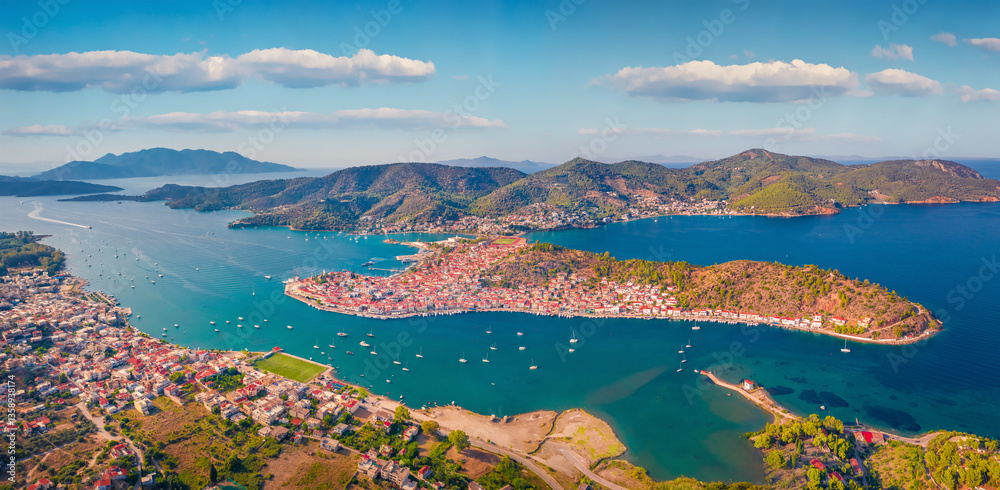 Adorable summer cityscape of Galatas town with public stadium. Incredible morning view of Poros port. Spectacular morning seascape of Myrtoan Sea. Traveling concept background.
