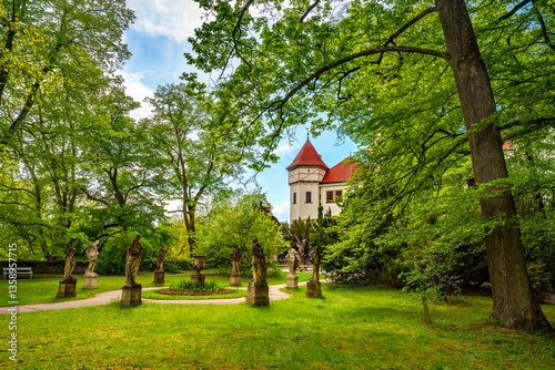 Konopiste castle, surrounded by stunning gardens and lush green trees, showcases beautiful statues in springtime, located near Benesov in the Czech Republic