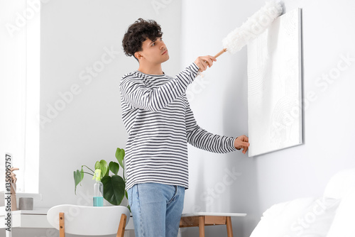 Young man cleaning painting...