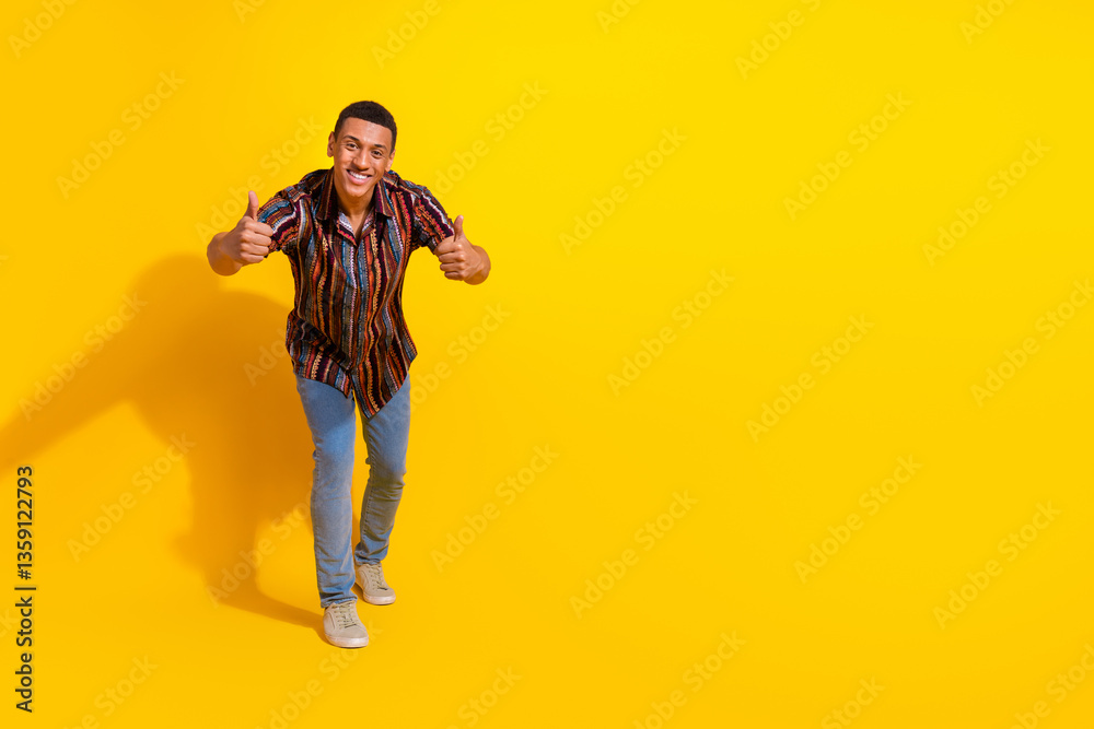 Happy male model gesturing thumbs up on a bright yellow background, wearing casual clothing and expressing joy and positivity Happy male model gesturing thumbs up on a bright yellow background, wearing casual clothing and expressing joy and positivity