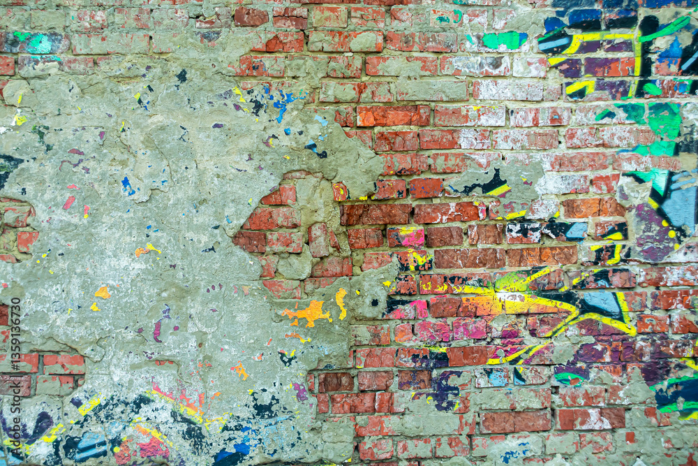 Naklejka premium Abstraction of crumbling graffiti on a city street wall. Colorful abstract background. Old, cracked, peeling paint on the wall as a background.