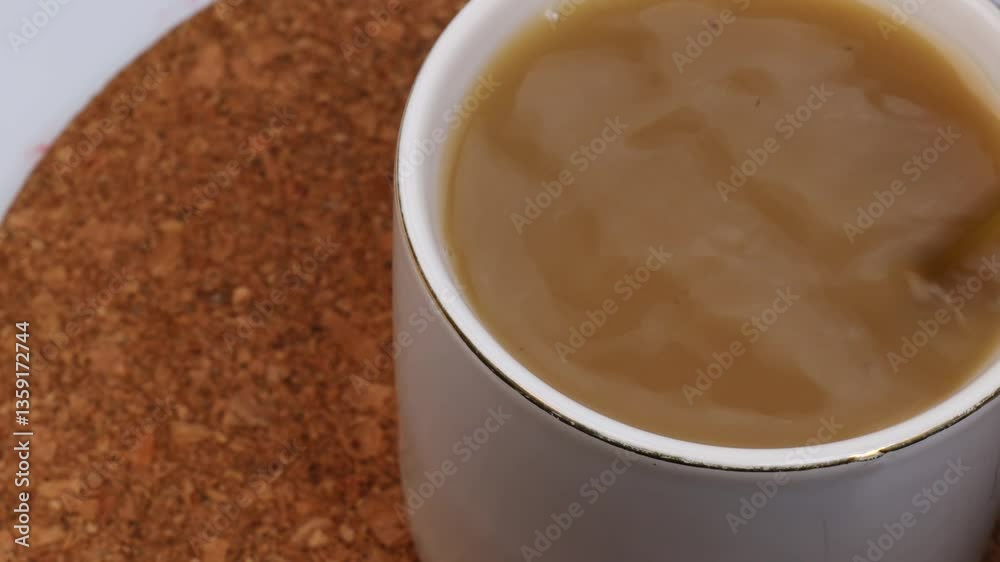 Stirring black tea with milk using spoon in warm cozy setting. Smooth swirl creates creamy texture in classic tea blend. Comforting tea preparation for relaxing moment. Stirring black tea with milk using spoon in warm cozy setting. Smooth swirl creates creamy texture in classic tea blend. Comforting tea preparation for relaxing moment.
