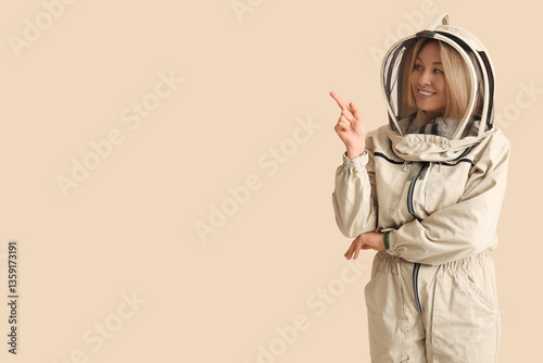 Female beekeeper pointing a...