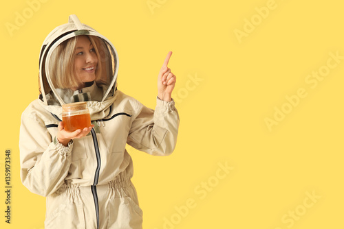 Female beekeeper with jar o...