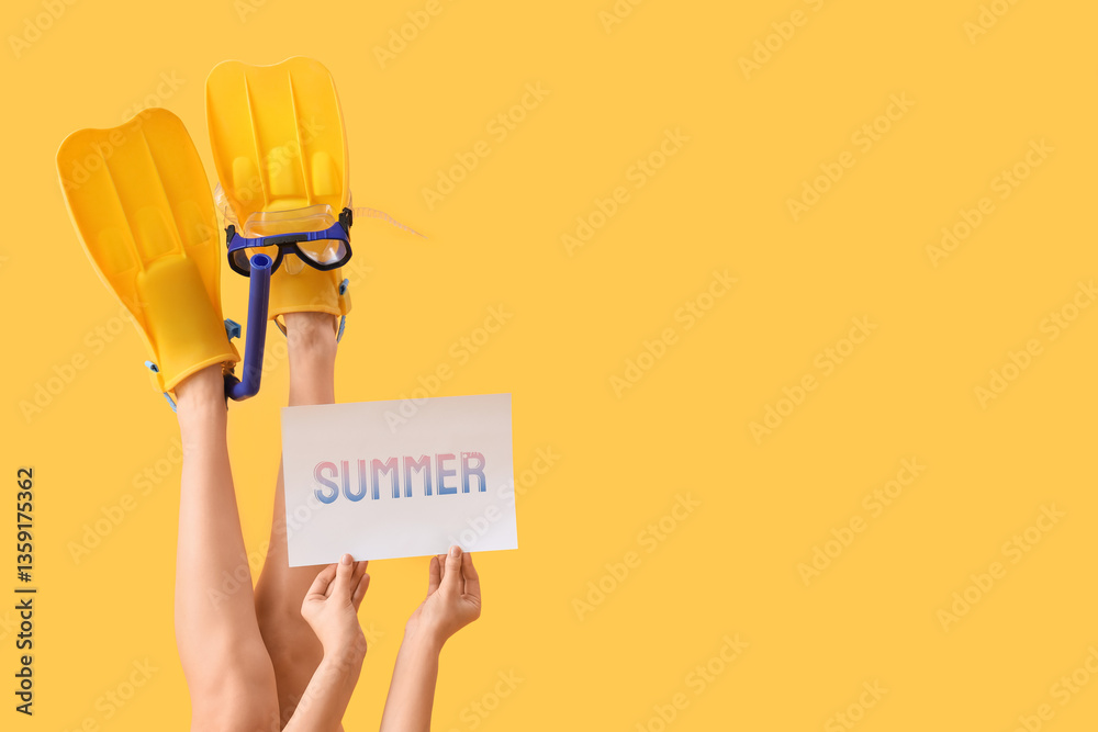 Fototapeta premium Young woman with flippers, diving mask and word SUMMER on yellow background