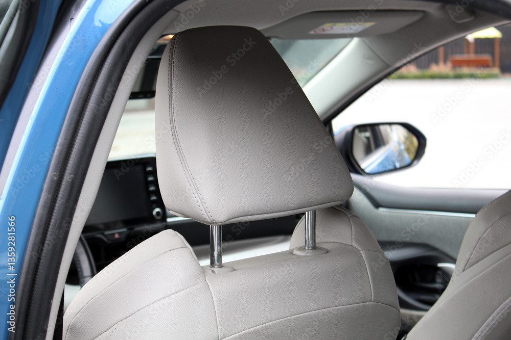 Close-up white headrest drivers seat made of genuine textile. Driver seat of a new vehicle. New light textile car interior. Beige textile car seats in the expensive car. Close-up white headrest drivers seat made of genuine textile. Driver seat of a new vehicle. New light textile car interior. Beige textile car seats in the expensive car.