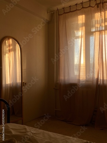 Bedroom interior with mirror and curtains in sunlight. Good morning. 