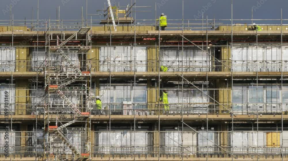 Building workers on scaffolding.
Telephoto shot of workers on scaffolding on a block of flats.