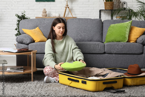 Young woman packing pillow ...