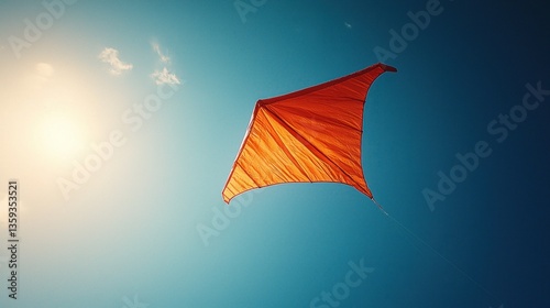 Orange kite in clear blue sky
