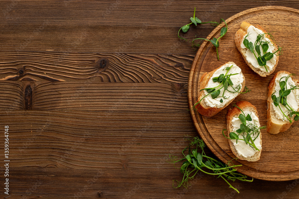 Toasts with fresh sprouting microgreens and cream cheese on wooden board, top view Toasts with fresh sprouting microgreens and cream cheese on wooden board, top view