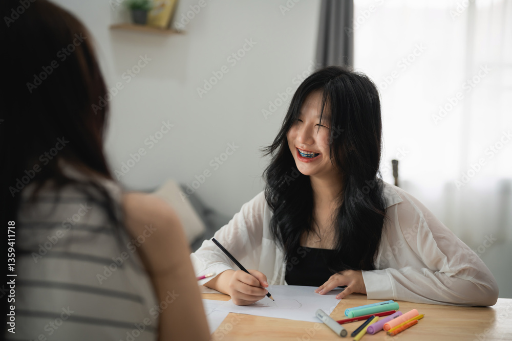 Asian Young Woman Smiling while Drawing with Colorful Markers in Bright Room, Creating Artwork and Enjoying Creative Moments with Friend Asian Young Woman Smiling while Drawing with Colorful Markers in Bright Room, Creating Artwork and Enjoying Creative Moments with Friend