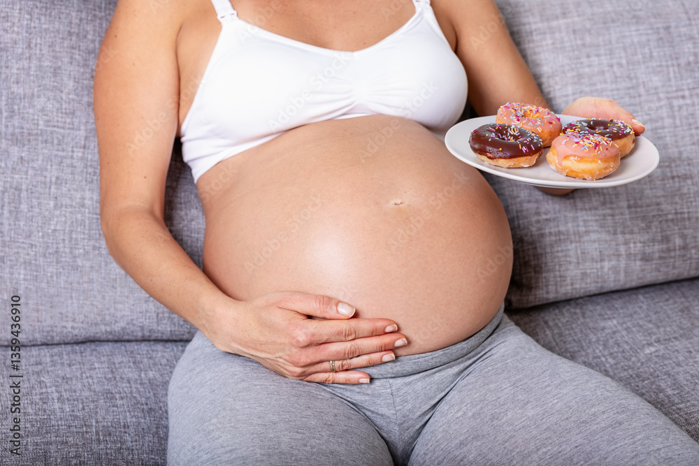 Close-up view of a pregnant woman eating doughnuts as a concept for non healthy food during maternity