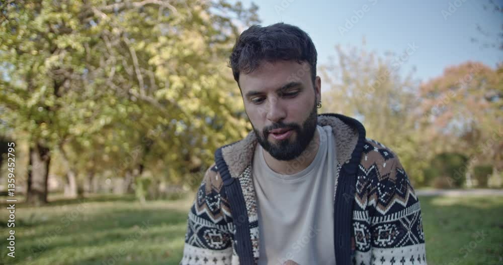 A young man sits in a park expressing a variety of emotions such as sadness, happiness, boredom, and anxiety. A young man sits in a park expressing a variety of emotions such as sadness, happiness, boredom, and anxiety.