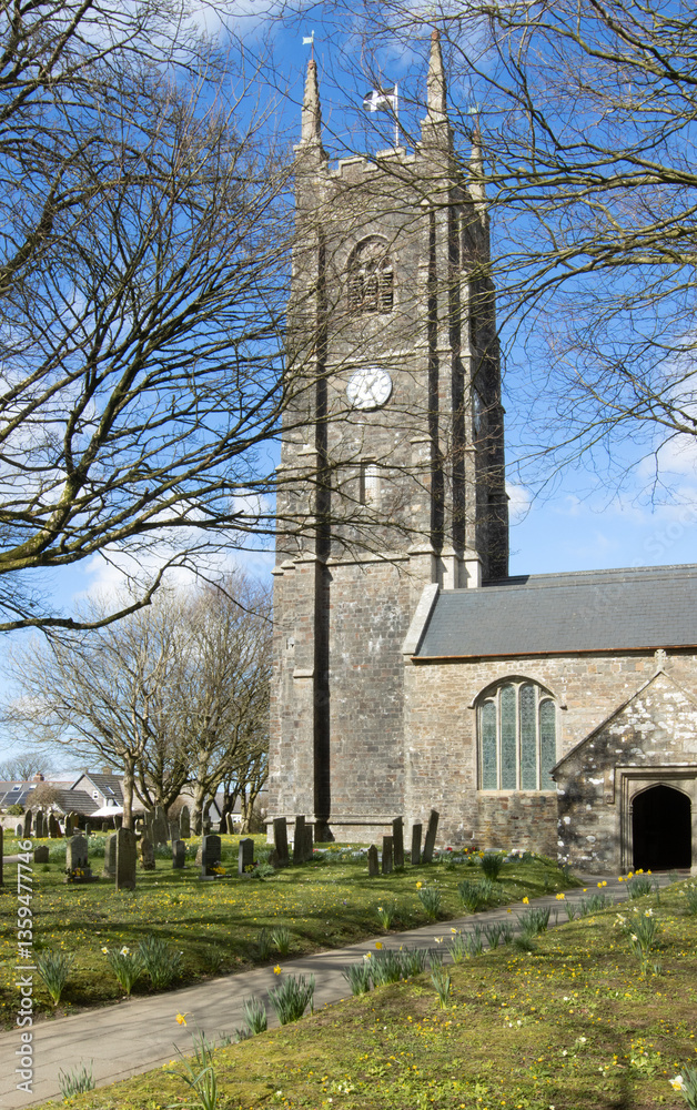 15th Century Norman 'St James the great' church with clock tower and Cornish flag in Kirkhampton in Cornwall during spring