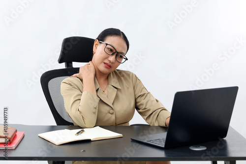Unhappy female working in the office sitting on office desk while using laptop computer, front view, isolated on white.