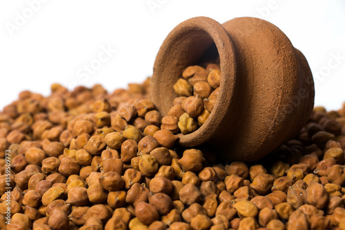 Fotografie Frontview of Organic Brown Chickpeas in a earthen clay pot Isolated on a white background