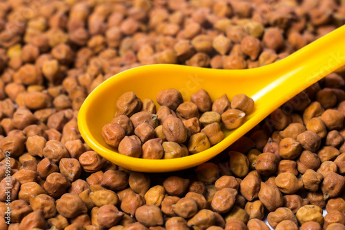 Obraz na plátně Closeup shot of Organic Brown Chickpeas in a Spoon
