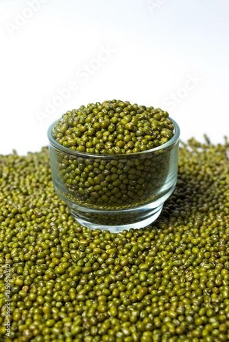 Fotografie Vertical shot of Green Moong Dal beans in a Glass Bowl Isolated on a white background