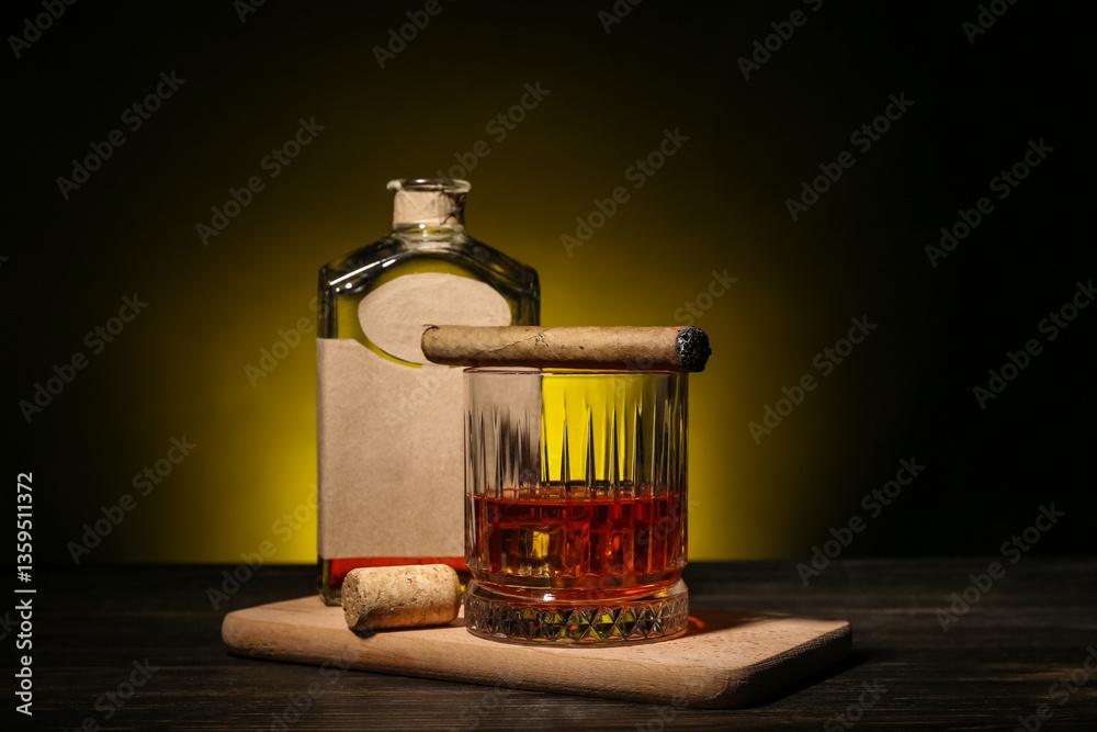 Εκτύπωση καμβά Bottle and glass of rum with cigar on wooden table against dark background