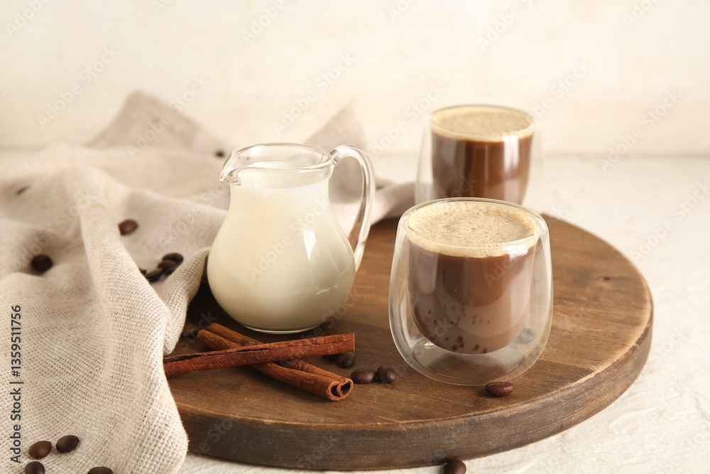 Glasses of hot coffee with cinnamon and jug of fresh milk on white background Glasses of hot coffee with cinnamon and jug of fresh milk on white background