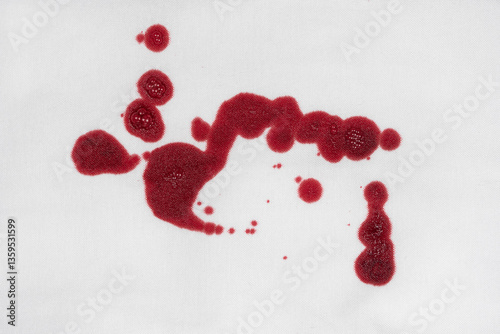Drops of blood stains on white fabric. blood splatters on clothes. red dripping blood spatters