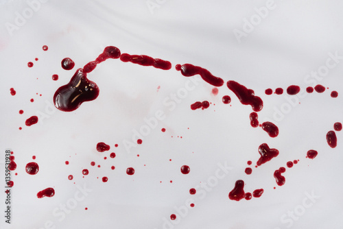 Drops of blood stains on white fabric. blood splatters on clothes. red dripping blood spatters