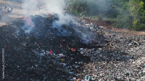 Burning dump in Asia. Pollution by plastic rubbish on landfill, drone view in Bali. 