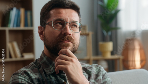 Portrait pensive thinking hesitate unsure think thoughtful confused puzzled Caucasian man male guy come up with idea finding answer creative solution insight smiling looking at camera at home indoors