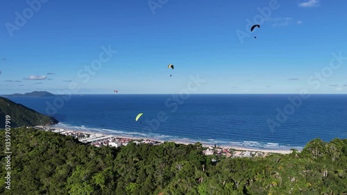 Paragliders soaring over beautiful coastal landscape in Brazil