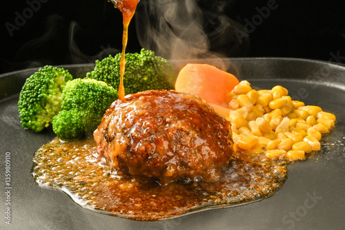 和風ハンバーグにソースをかける