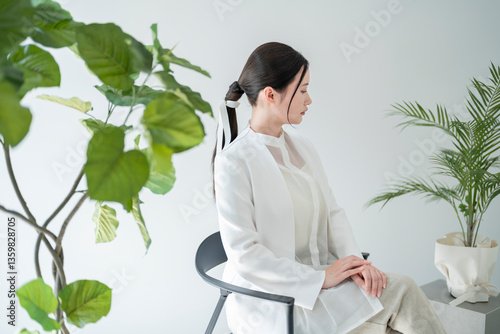 植物に囲まれた部屋の女性