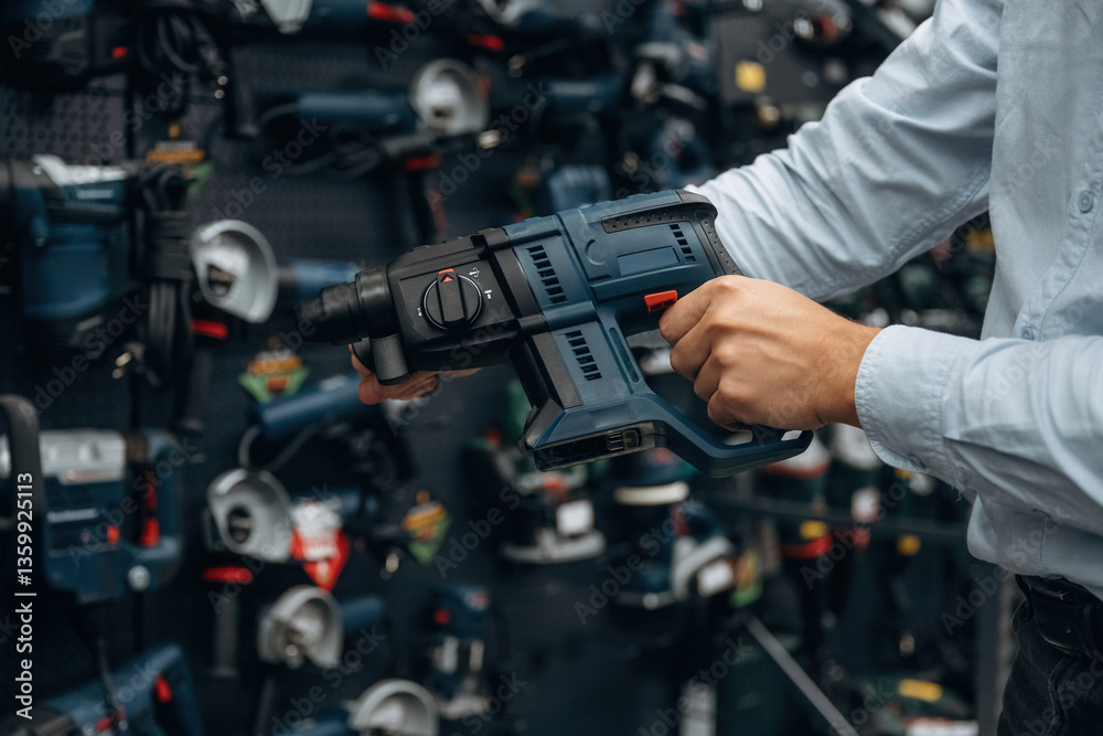Perforator drill. Detailed close up view of man's hand in the hardware store Perforator drill. Detailed close up view of man's hand in the hardware store