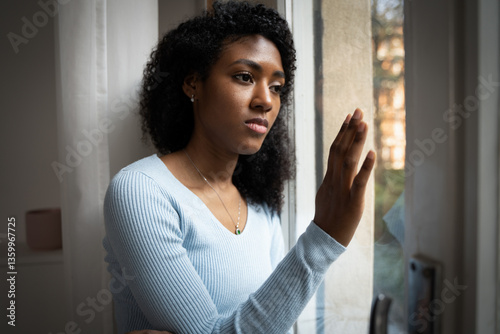 A black woman very sad thinking in front of window
