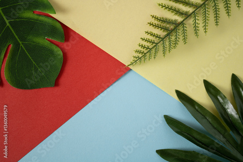 Three different green flower petals on a wall of red, yellow and blue colors
