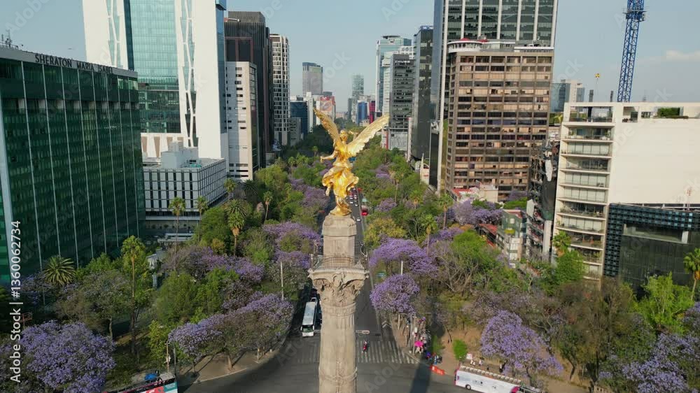 Mexico city Angel de la independencia landmark in downtown, spring with purple flowers jacarandas in paseo de la reforma av