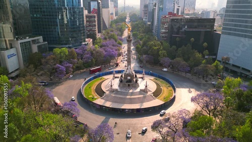 Mexico city Angel de la independencia landmark in downtown, spring with purple flowers jacarandas in paseo de la reforma av